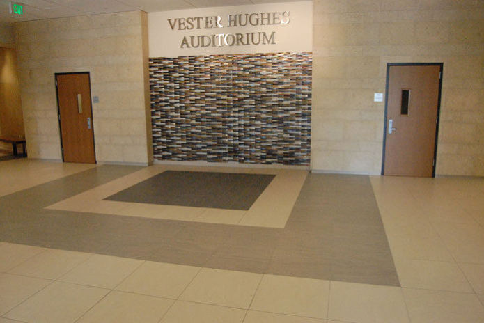 SMU Caruth Hall, auditorium entry with a mosaic tile feature wall and a stone floor