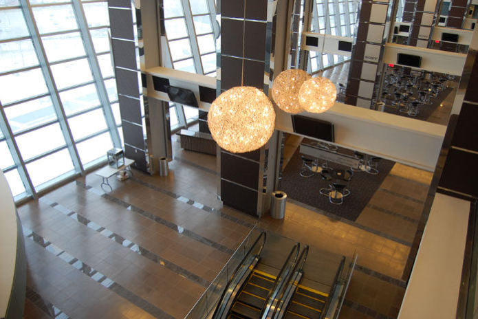 Cowboys Stadium, concourse with a glass wall, escalators, and a tiled floor with dark bands
